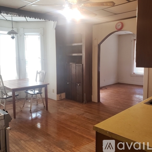 A room with wooden floors and a table with chairs.