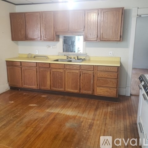 A kitchen with wooden cabinets and a white stove.