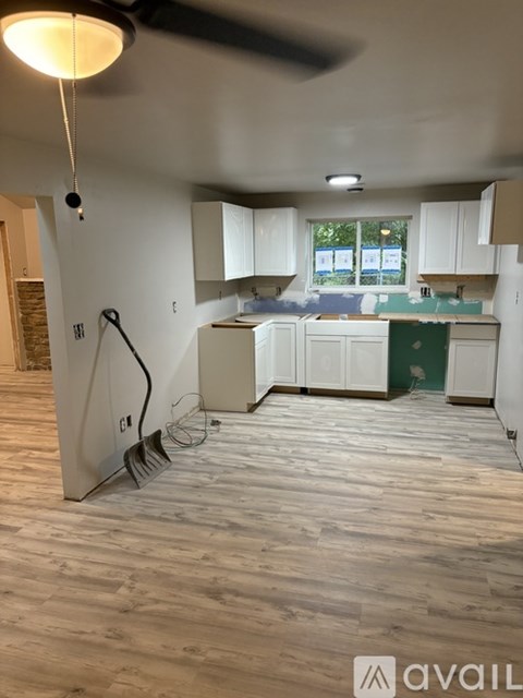 A kitchen with white cabinets and a wooden floor.