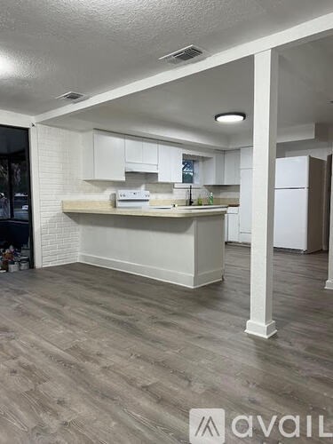 A kitchen with white cabinets and a wooden island.