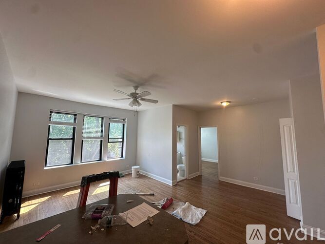 A room with a ceiling fan and a window with blinds.