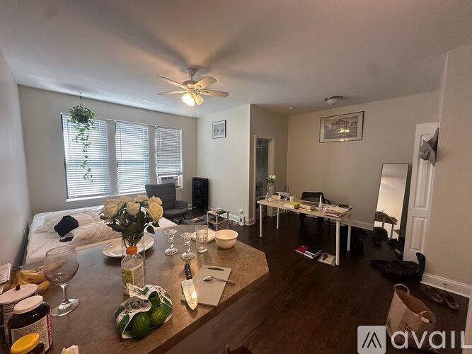 A living room with a dining table set for two and a kitchen area.