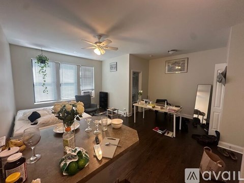 A living room with a dining table set for two and a kitchen area.