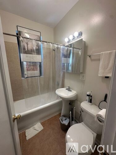 A small bathroom with a toilet, sink, and a mirror.