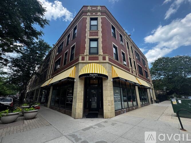 A building with a red brick facade and a yellow awning.