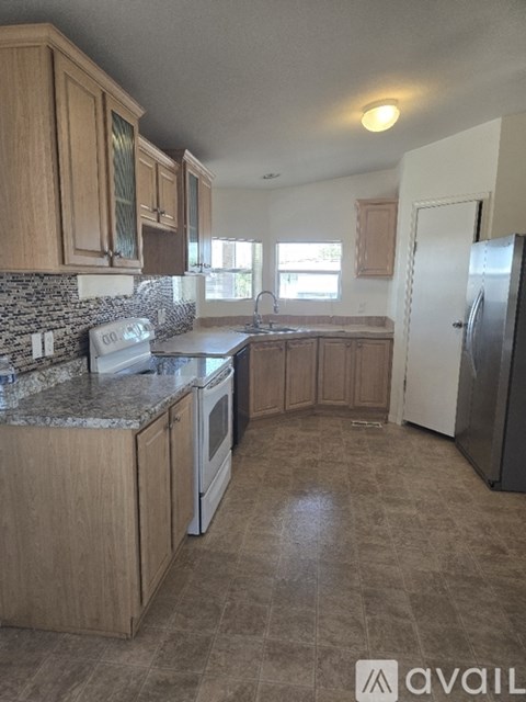 A kitchen with wooden cabinets and a granite countertop.