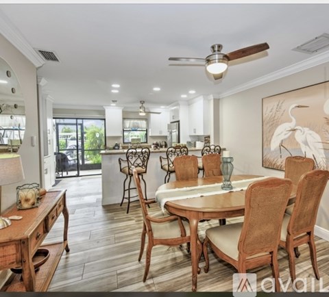 A dining room with a wooden table and chairs.