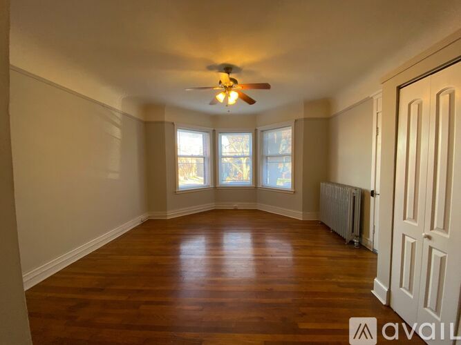 A room with wooden floors and a ceiling fan.