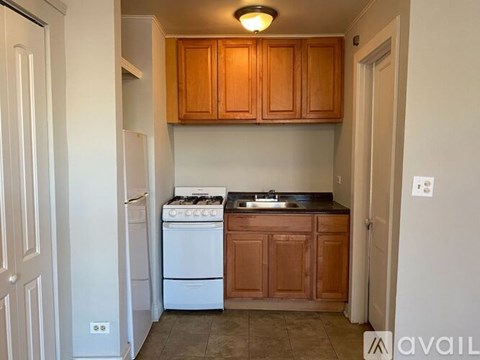 A kitchen with wooden cabinets and a white stove top oven.