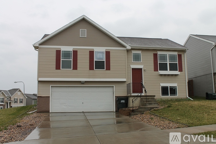 A two-story house with a garage and a driveway.