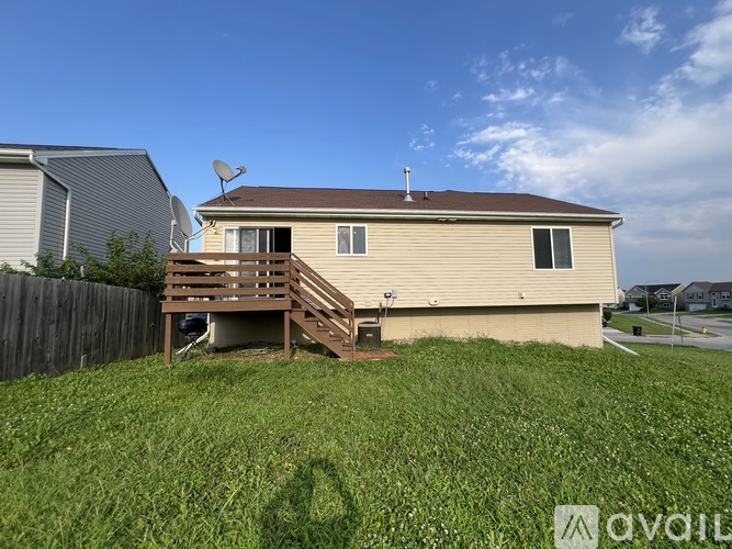 A house with a brown roof and a deck in the front yard.