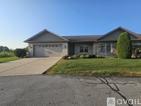 A house with a grey garage door and a driveway in front.