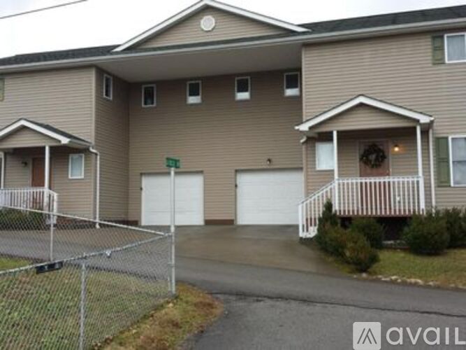 A two-story house with a garage and a driveway.
