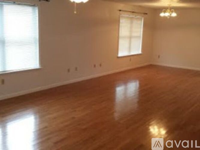 A room with wooden floors and a chandelier.