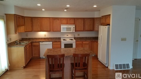 A kitchen with wooden cabinets and a white oven.
