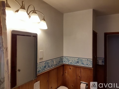 A bathroom with a toilet, sink, and mirror.