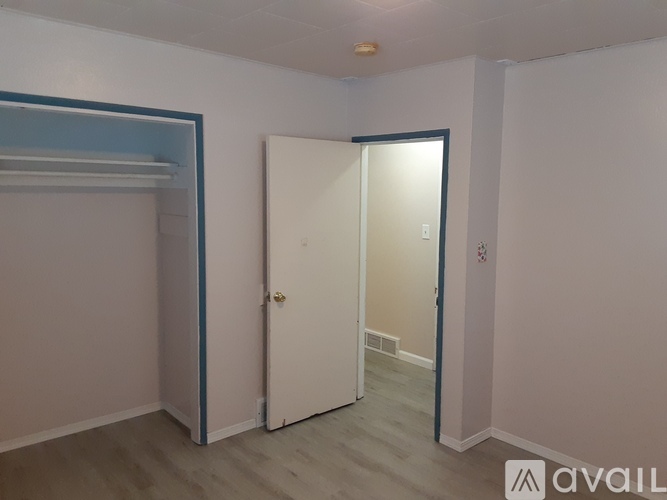 A room with a white door and a blue stripe on the wall.