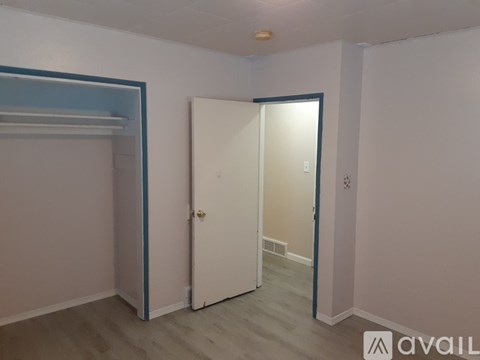A room with a white door and a blue stripe on the wall.
