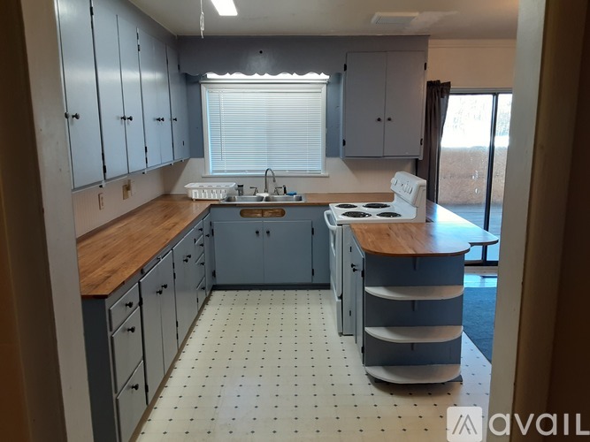 A kitchen with blue cabinets and a white stove top oven.
