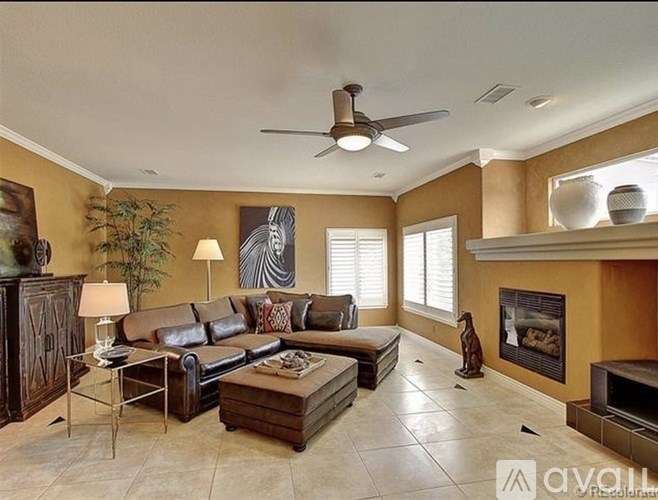 A living room with a brown leather couch and a wooden cabinet.