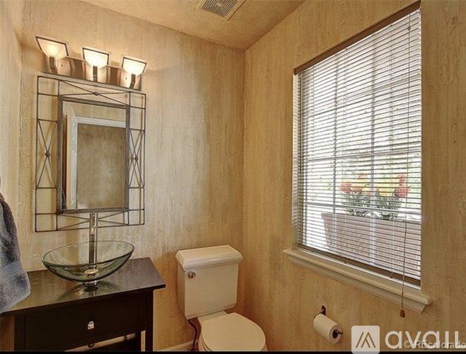 A bathroom with a toilet, a mirror, and a window.