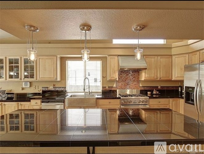 A kitchen with wooden cabinets and a black countertop.
