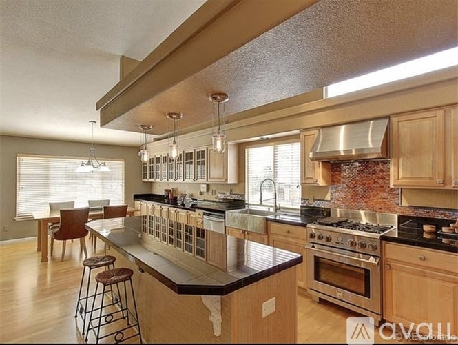 A kitchen with wooden cabinets and a black countertop.