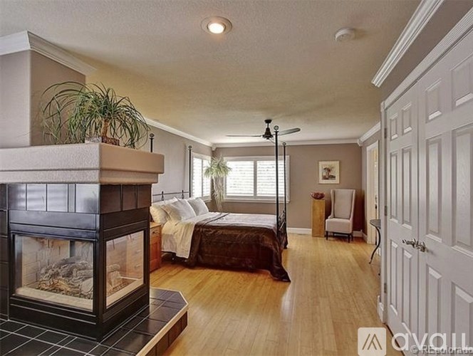 A bedroom with a fireplace and a bed.