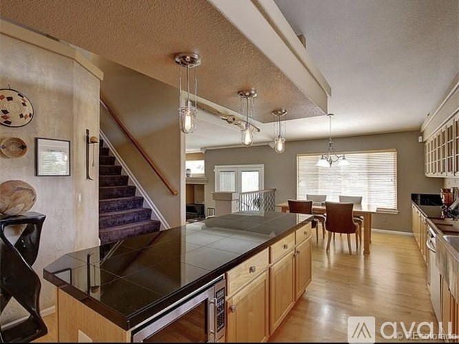 A kitchen with wooden cabinets and a black countertop.
