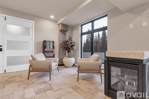 A living room with a fireplace and two chairs.