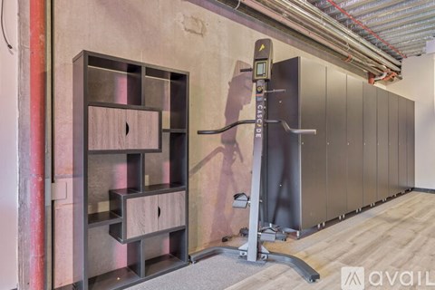 A gym with a squat rack and a wall-mounted pull up bar.