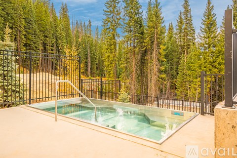 A hot tub sits in the middle of a forest.