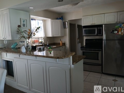 A kitchen with white cabinets and granite countertops.