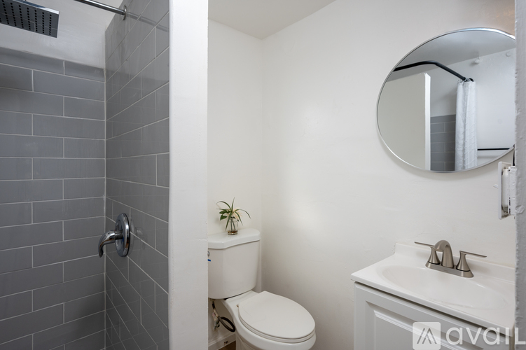 A bathroom with a toilet, sink, and mirror.