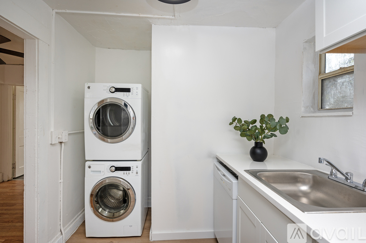 A white laundry room with a washer and dryer stacked on top of each other.