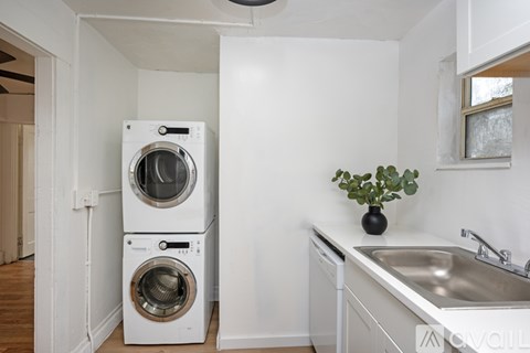 A white laundry room with a washer and dryer stacked on top of each other.
