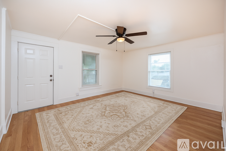A room with a ceiling fan and a window with blinds.