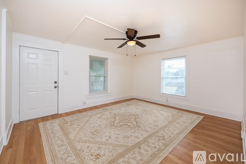 A room with a ceiling fan and a window with blinds.