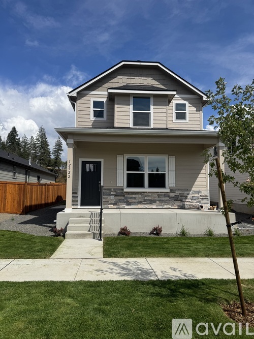 A two-story house with a front porch and a black door.