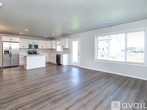 A spacious kitchen with white cabinets and a large island.
