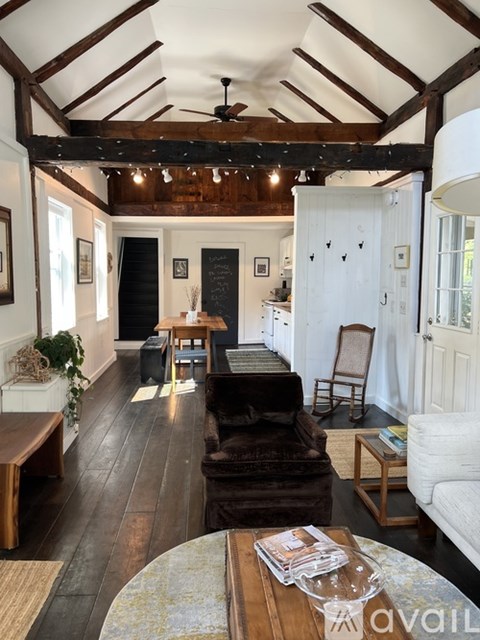 A living room with a dark brown leather couch and a wooden coffee table.