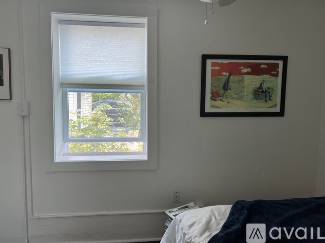 A room with a window and a picture on the wall.