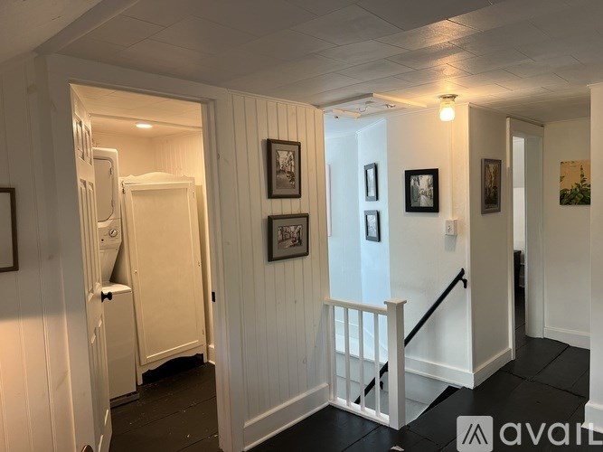 A hallway with a white door and a staircase.