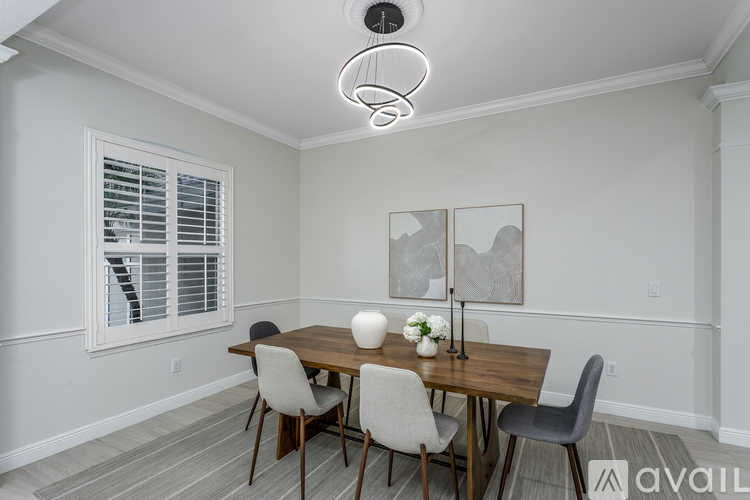 A dining room with a large table and chairs.