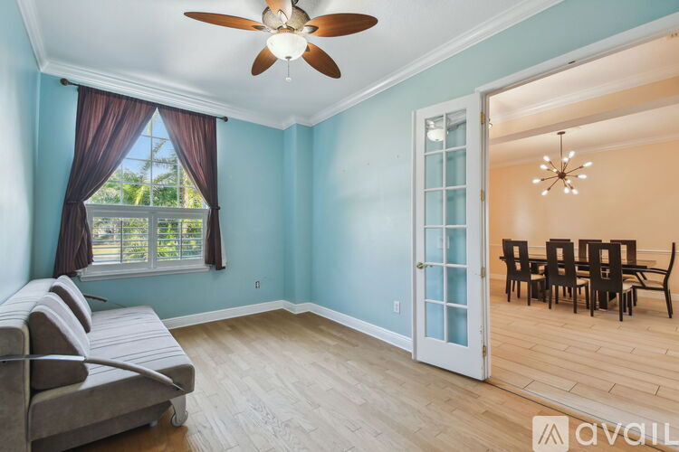 A living room with a grey sofa and a ceiling fan.