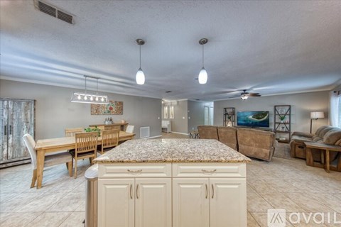 A living room with a dining table and chairs, a couch, and a cabinet.
