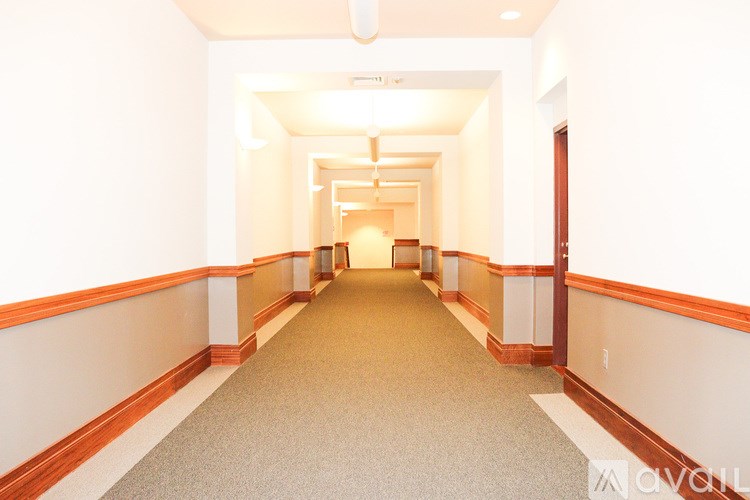 A long hallway with a carpeted floor and white walls.