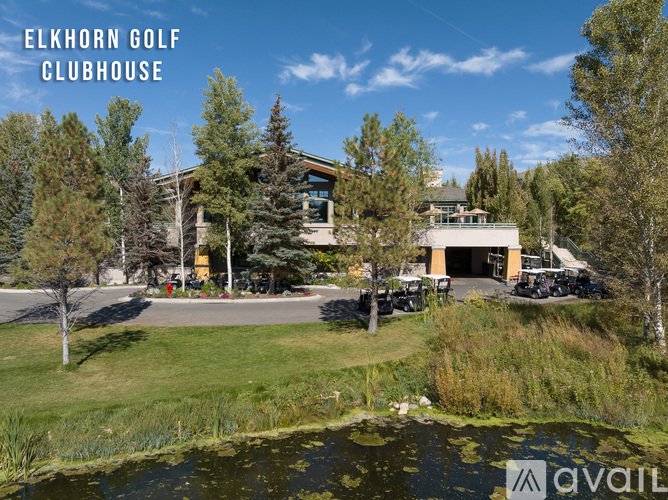 A clubhouse with a pond in front of it.