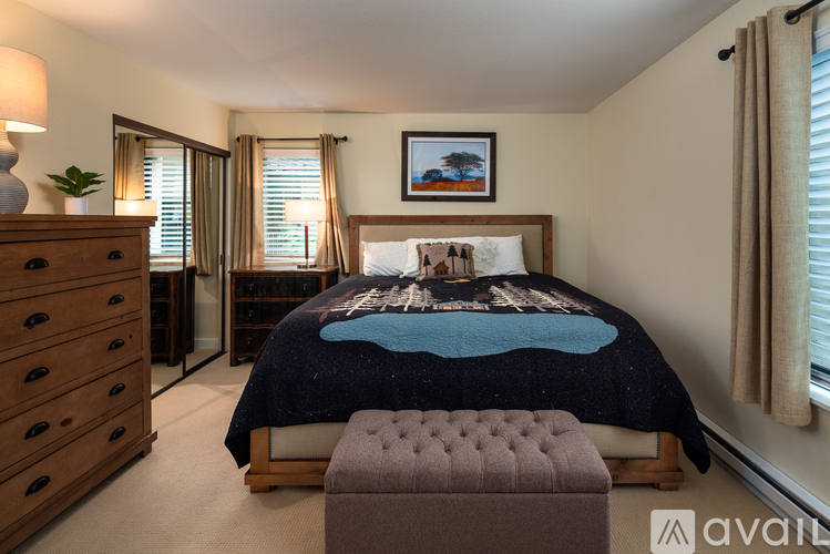 A bedroom with a bed, a dresser, and a painting on the wall.