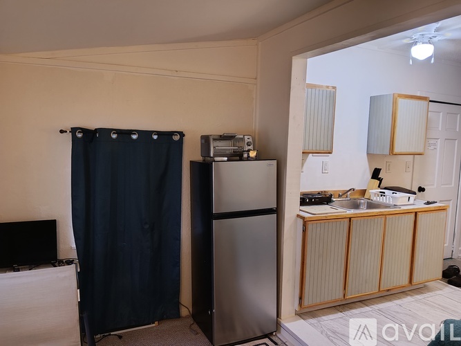 A kitchen area with a refrigerator, a sink, and a cabinet.